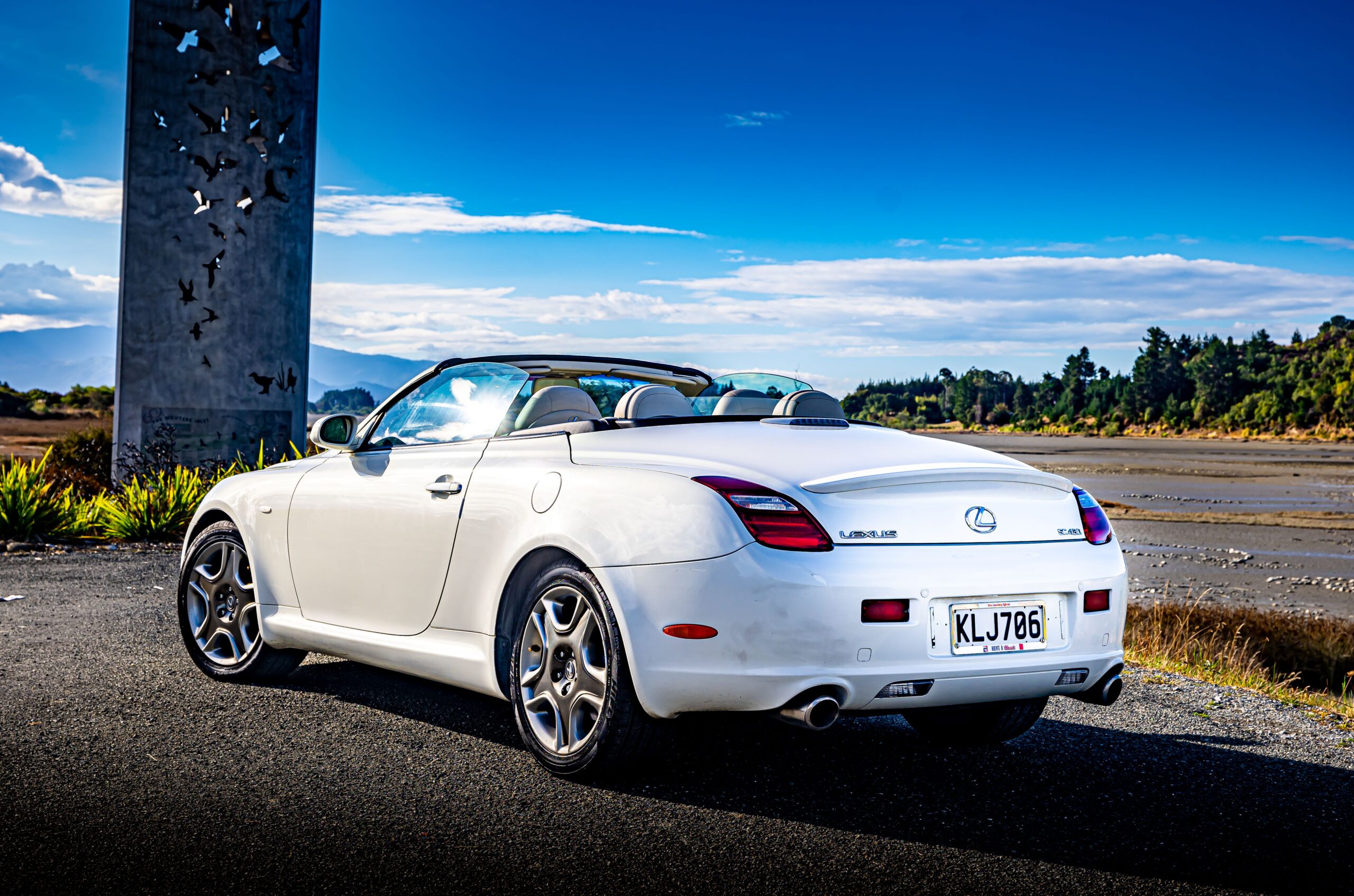 RentAClassics Lexus SC430 convertible roof down by tall metal sculpture